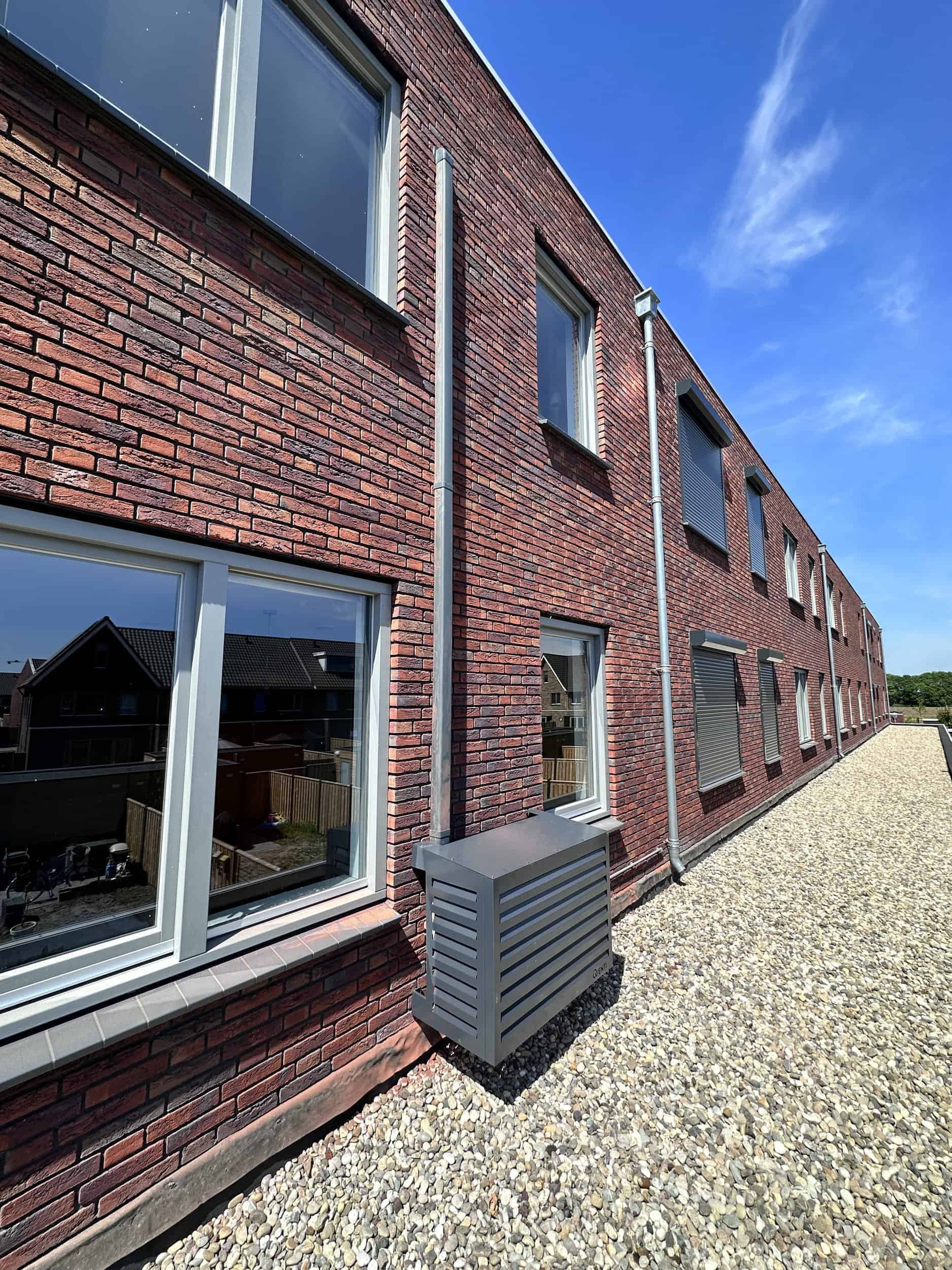 Moderne bakstenen woning met grote ramen en grindpad